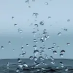 Wassertropfen fallen auf eine Wasseroberfläche